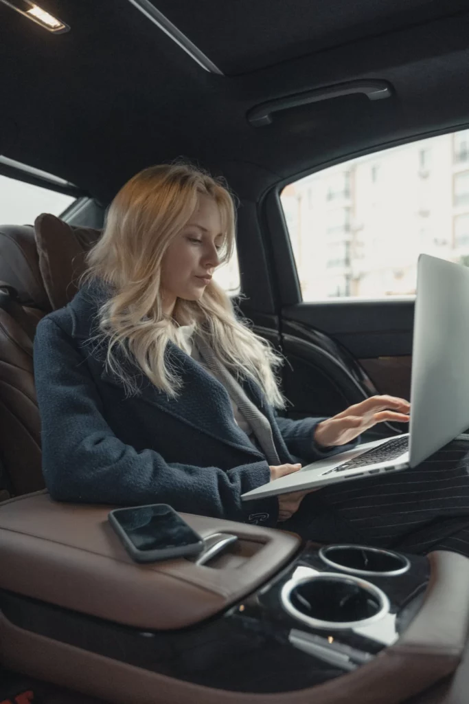 Geschäftsfrau die im Auto sitzt und an ihrer Escort Bewerbung arbeitet